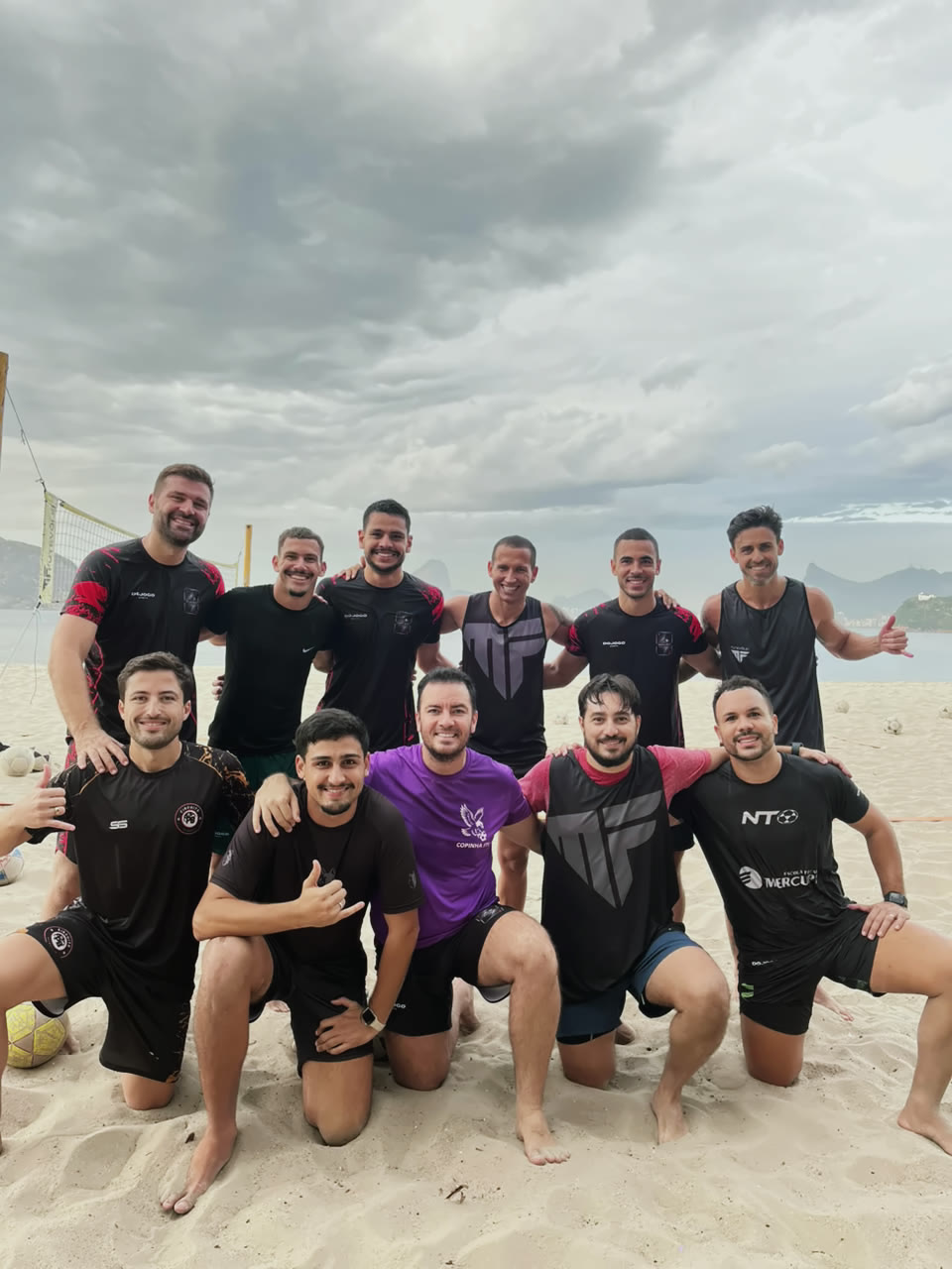 Turma avançada da MF Futevôlei com o uniforme da escola na areia de Icaraí